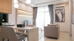 A modern living room with a marble coffee table, two sofas, and a dining area with chairs.