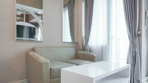 Ein modernes, minimalistisches Zimmer mit einem beigen Sofa, einem weißen Konsolentisch und einem großen Fenster mit grauen Vorhängen.