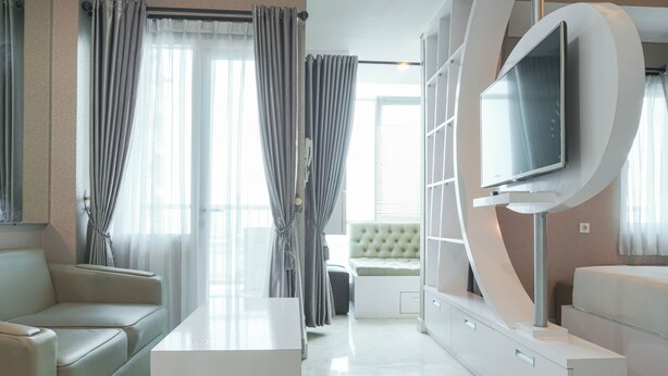Ein modernes Wohnzimmer mit einer Couch, einem Couchtisch und einem an einer weißen Wand befestigten Fernseher.