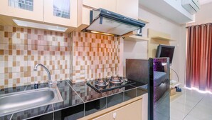 Une cuisine équipée d’une cuisinière à gaz, d’un évier et d’un réfrigérateur.