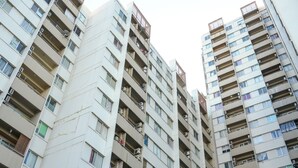 Un edificio residencial de gran altura con múltiples balcones, unidades de aire acondicionado y un diseño arquitectónico moderno.