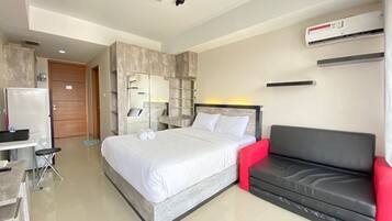Relax in a spacious room with a large bed, sofa, and wardrobe.