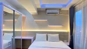 Ein modernes Hotelzimmer mit Bett, Nachttisch und Spiegel.