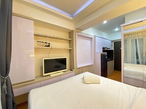 Une chambre d’hôtel comprenant un lit, une télévision, une armoire et une salle de bain.