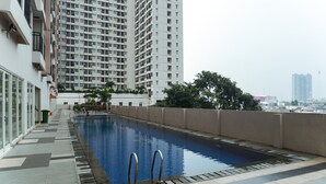 A rooftop swimming pool with a view of high-rise buildings. - Simply Studio Room Apartment Margonda Residences 5 (Depok)