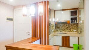 Una cucina moderna con un piano di lavoro in legno, uno schienale piastrellato e un divisorio in vetro.