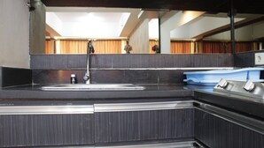 A bathroom with a sink, mirror, and a blue soap dish. - Deluxe & Comfy 2BR at Braga City Walk Apartment (Bandung)