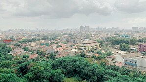 A cityscape with a mix of residential and commercial buildings, dense urban layout, and a prominent mosque with a dome. - Cozy and Simply 1BR Green Pramuka Apartment (Jakarta)