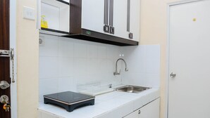 A compact kitchen with white cabinets, a stainless steel sink, and a black countertop scale. - Comfy 2BR Mutiara Bekasi Apartement (Bekasi)