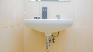 A bathroom sink with a mirror above it, a faucet, and two soap dispensers. - Comfy Studio at The Springlake Summarecon Apartment (Bekasi)
