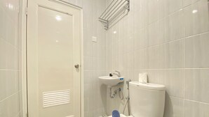 A bathroom with a toilet, sink, and shower.