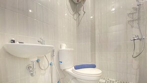 A bathroom with a toilet, sink, and shower.