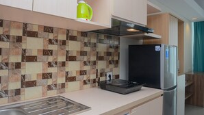 A modern kitchen with a tiled backsplash, a stainless steel refrigerator, and a built-in oven.