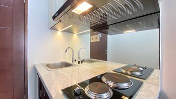 Kamer | Privékeuken | Een koelkast, een kookplaat, een vaatwasser, kookgerei, borden en bestek