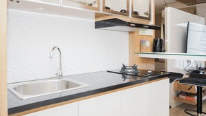 Una cocina moderna con un lavamanos de acero inoxidable, encimera negra y armarios de madera.