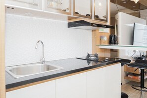 Room | Private kitchen | Fridge, stovetop, cookware/dishes/utensils - Comfy and Minimalist Studio Apartment at Tuscany Residences (South Tangerang)