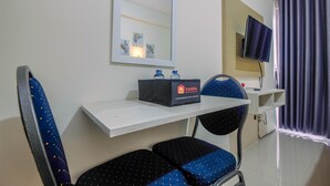 A room with a bed, a bedside table, a chair, a TV, and a window with curtains.