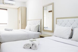 Habitación de hotel con dos camas, ropa blanca, un armario de madera, un espejo y una ventana.