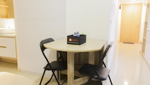 Ein kleiner runder Tisch mit einer schwarzen Box mit dem Aufdruck „travello“ und zwei schwarzen Stühlen.