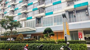 A multi-story building with balconies, air conditioning units, and a sign indicating a no parking zone. - Fully Furnished with Comfortable Design Studio Apartment H Residence (Jakarta)