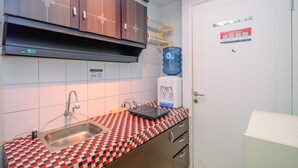 Une cuisine avec un plan de travail à motifs, un évier, un distributeur d’eau et des armoires en bois.