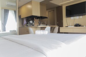 Une chambre d’hôtel équipée d’un lit, d’un bureau, d’une chaise, d’un téléviseur à écran plat et d’une fenêtre avec des rideaux.