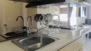 A modern kitchen with stainless steel appliances, a double sink, and a dish drying rack.