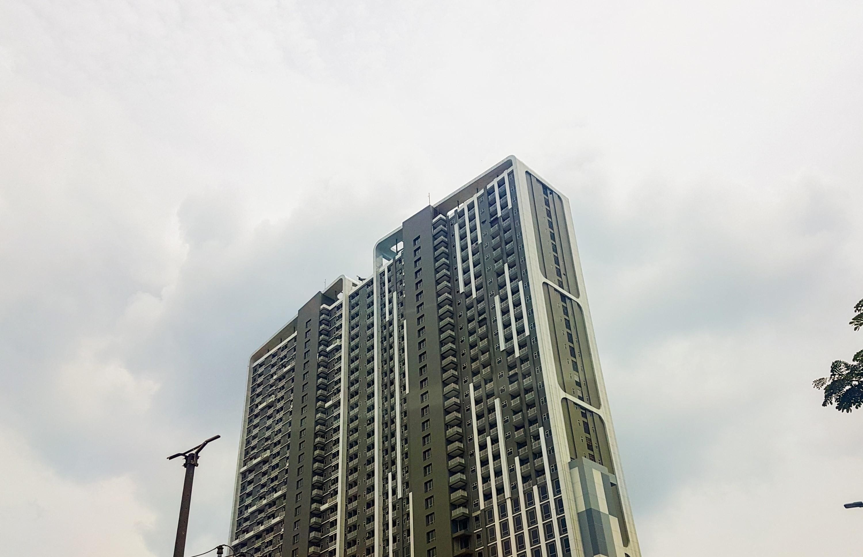 A high-rise building with multiple balconies and a modern architectural design.