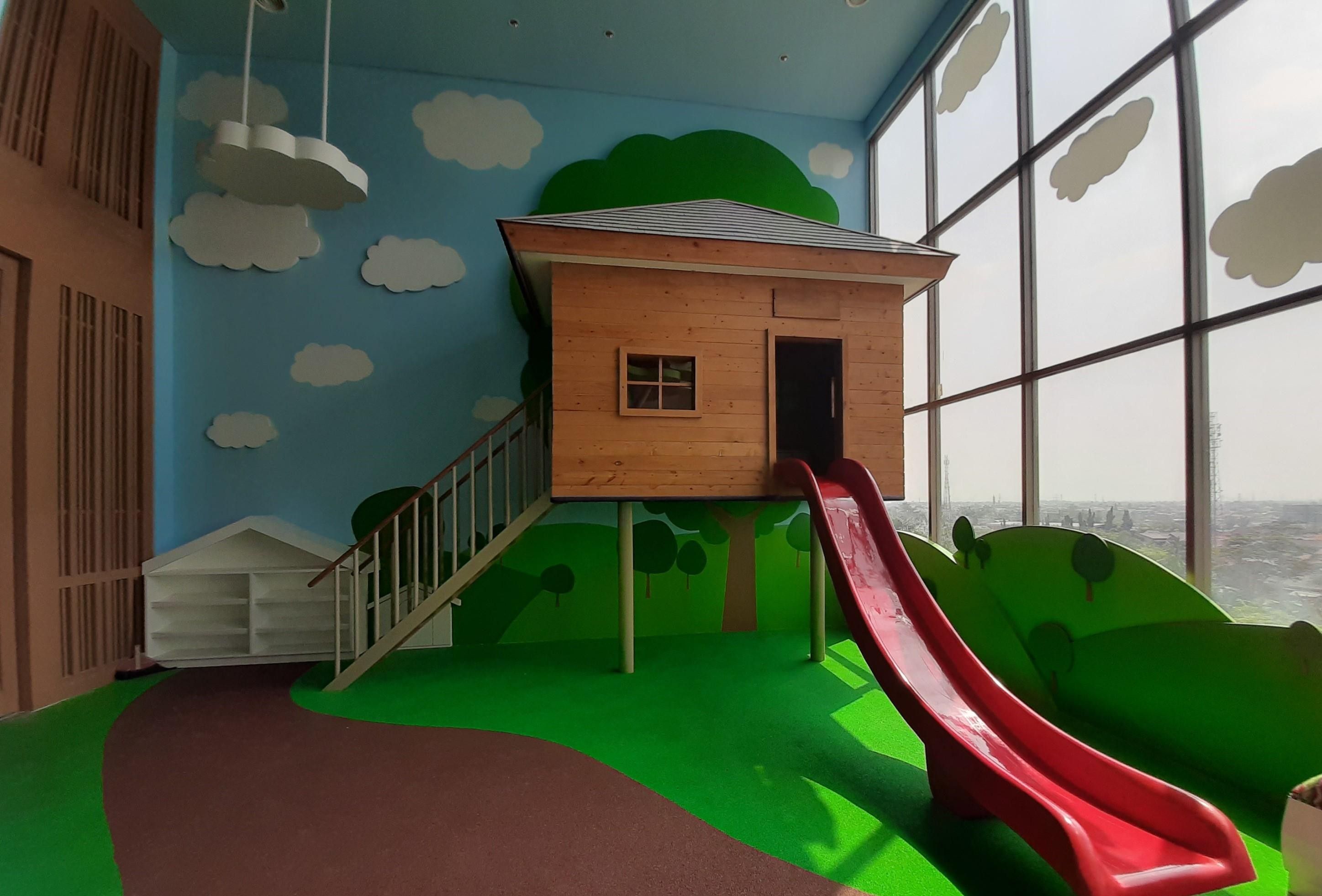 A children's play area with a slide, a playhouse, and a view through large windows.