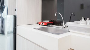 Una cocina moderna con un lavamanos de acero inoxidable, un electrodoméstico rojo y un espejo grande sobre la encimera.