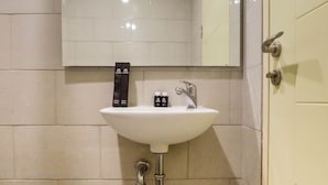 A bathroom with a white sink, a mirror above it, and a towel hanging on the wall. - Best Studio Benson Apartment Connected to Pakuwon Mall next to Anderson (Surabaya)