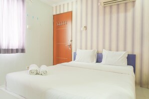 Comfortable accommodations feature a neatly made bed with crisp linens and two pillows.