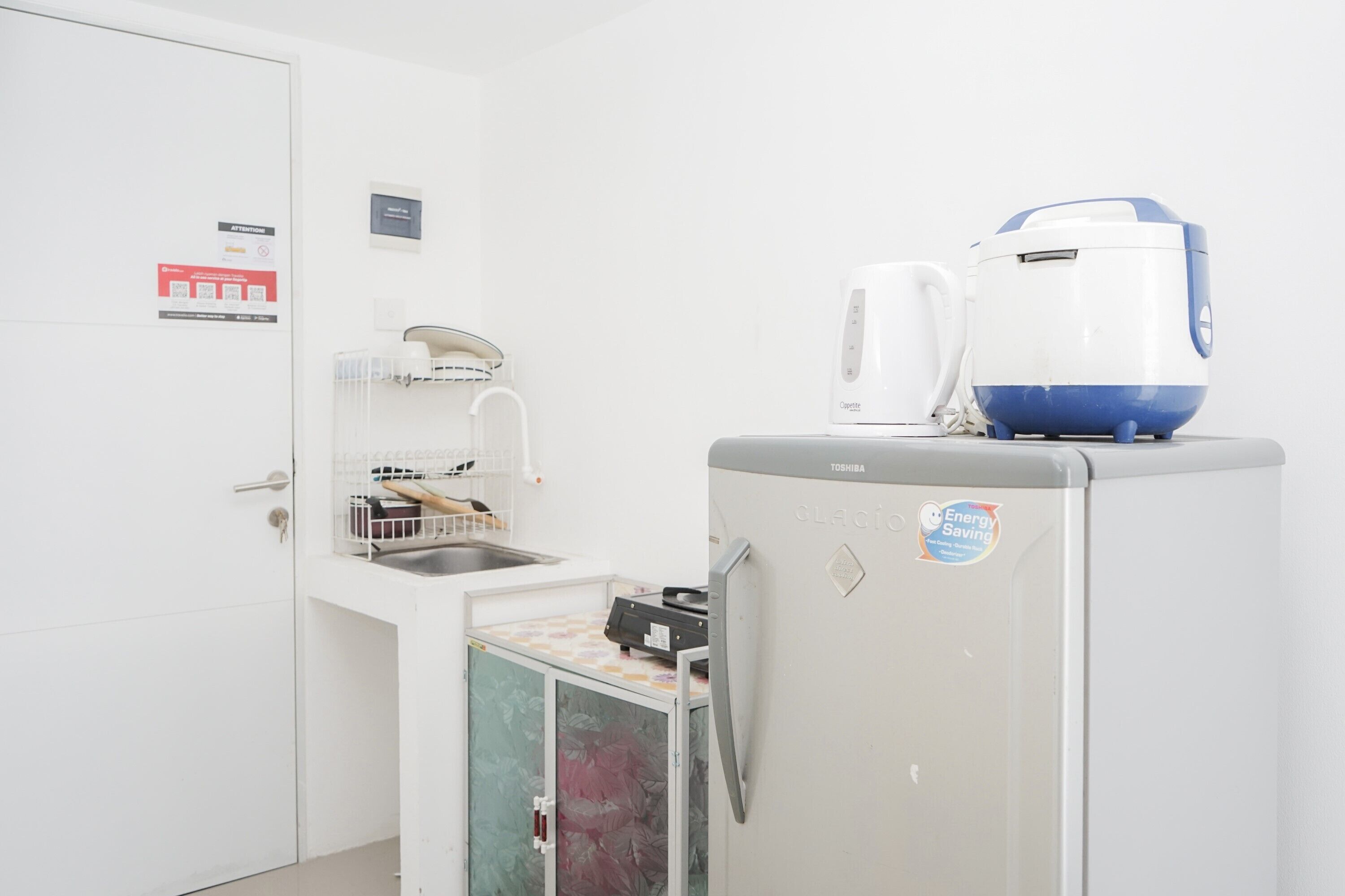 Eine kleine Küche mit Kühlschrank, Mikrowelle und Kaffeemaschine.