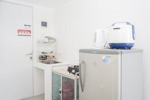 A compact kitchen with a refrigerator, a microwave, and a coffee maker.