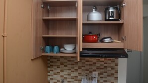 A kitchen with wooden cabinets, a stove, and a tiled backsplash.