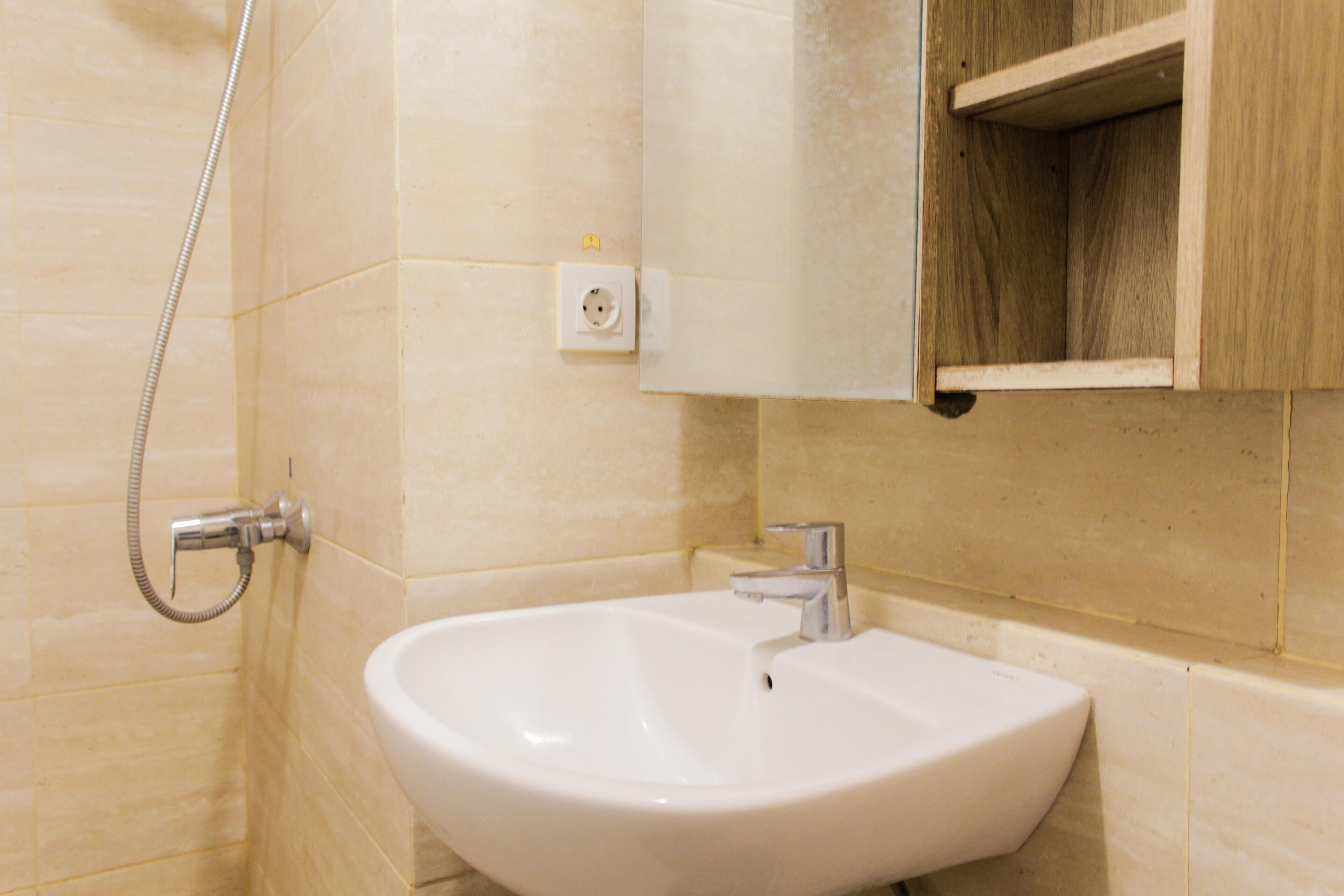 A bathroom with a white sink, a mirror, and a shower.