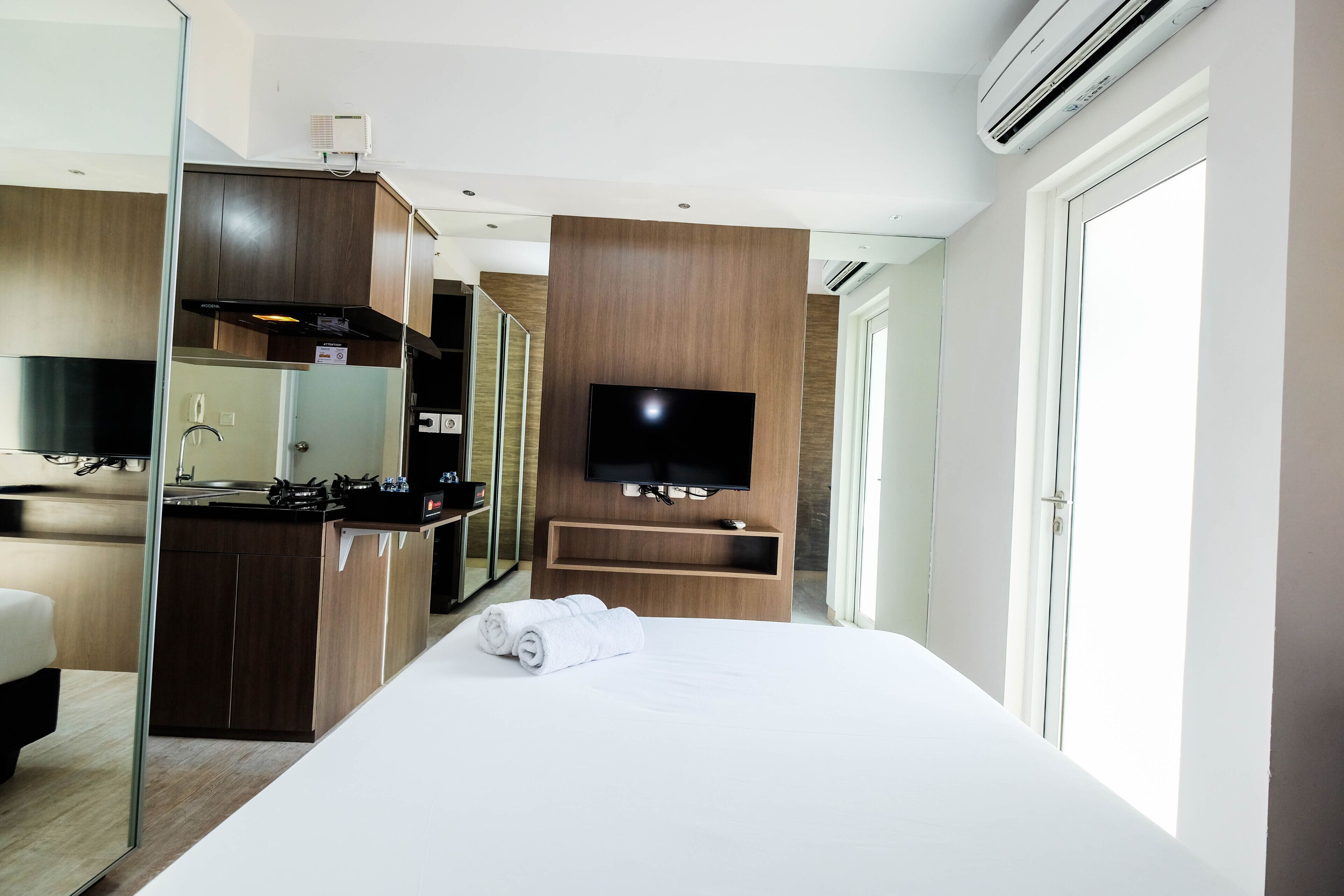 Une chambre d’hôtel comprenant un lit, une télévision, un coin cuisine et une salle de bain.