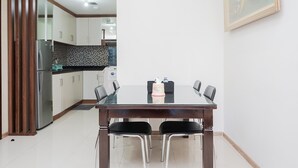 Eine moderne Küche mit weißen Schränken, einer schwarzen Arbeitsplatte und einem Edelstahl-Kühlschrank.
