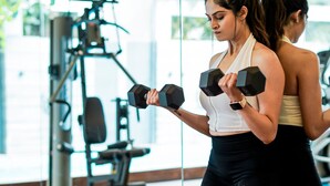 Un gimnasio con equipo de ejercicio y un espejo grande.