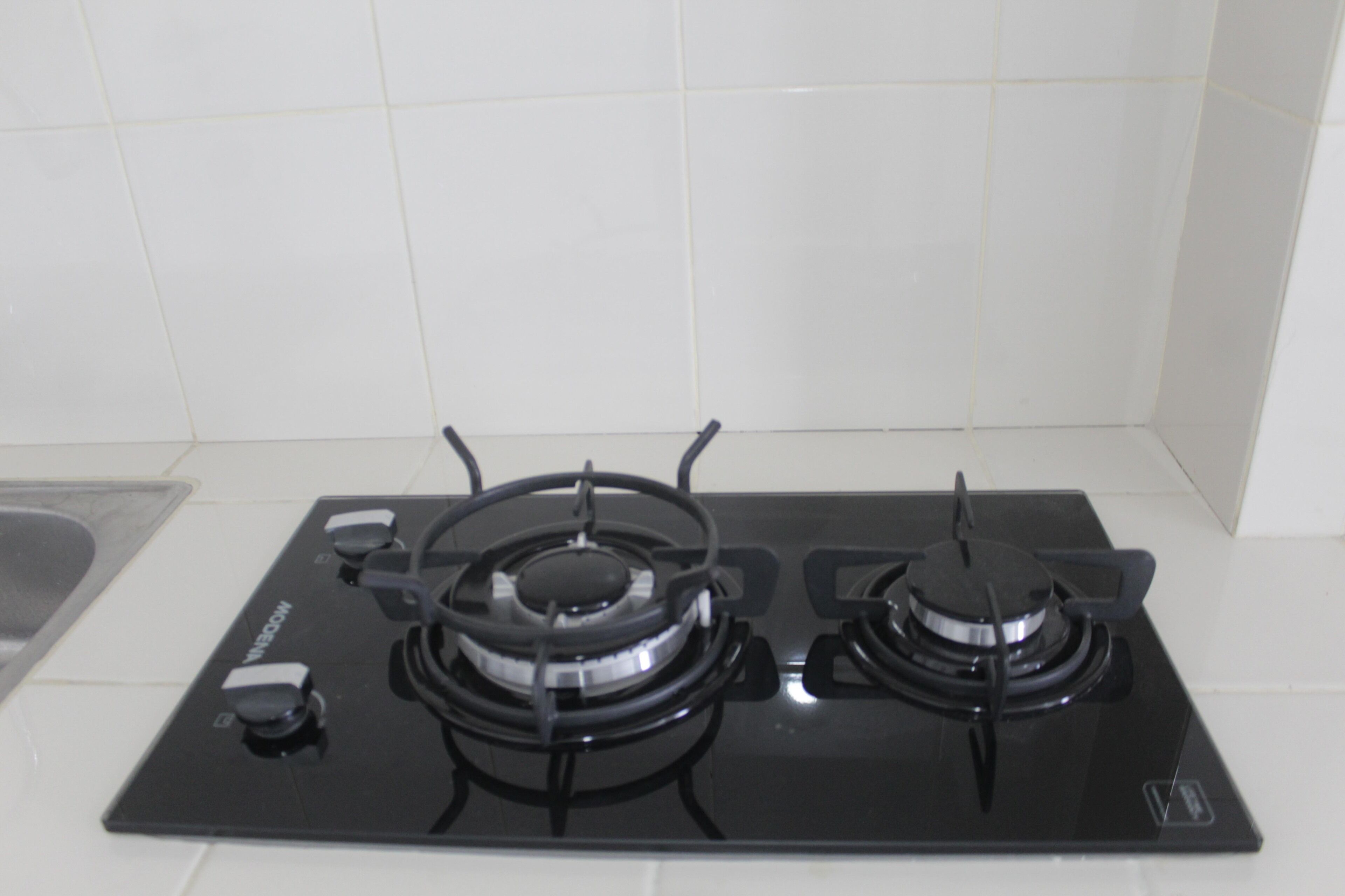 Una estufa a gas negra con cuatro quemadores y un panel de control.