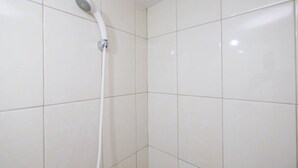A shower with a handheld showerhead in a tiled bathroom. - Comfortable Springlake Summarecon Studio Apartment near Mall (Bekasi)
