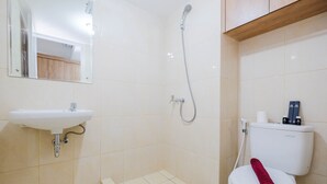 A bathroom with a sink, toilet, shower, and a mirror. - Comfort and Strategic Studio at Springlake Summarecon Bekasi Apartment (Bekasi)