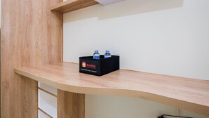 A wooden shelf with a black box labeled 'Travelio' containing two bottles. - Comfort and Strategic Studio at Springlake Summarecon Bekasi Apartment (Bekasi)