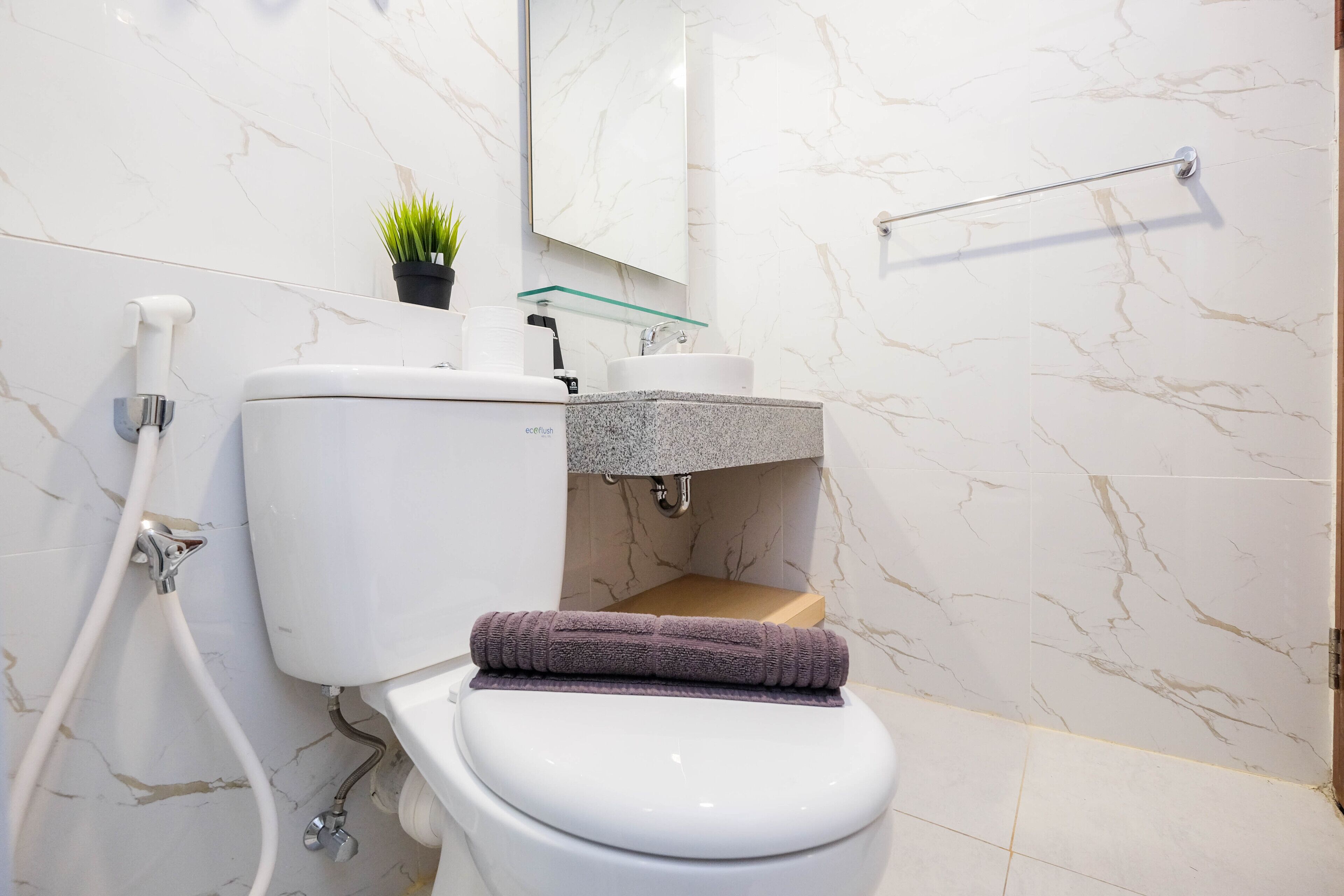 A modern bathroom with a toilet, sink, and shower.