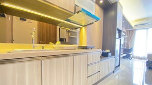 A modern kitchen with a large island, stainless steel appliances, and a bright, well-lit space. - Luxurious Studio Room at Galeri Ciumbuleuit 3 near UNPAR (Bandung)
