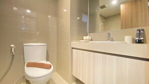A modern bathroom with a toilet, shower, and vanity. - Luxurious Studio Room at Galeri Ciumbuleuit 3 near UNPAR (Bandung)