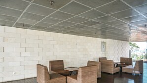 Uma área de estar interna moderna com móveis de vime e teto de metal.