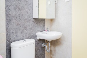 A bathroom with a toilet and a sink. - Spacey 2BR Apartment at Great Western Resort (Tangerang)