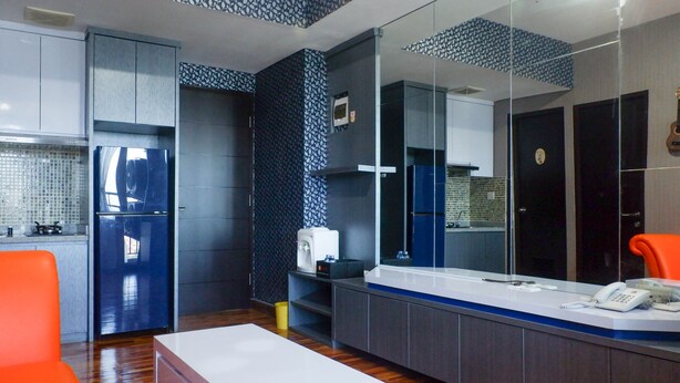 A modern kitchen with grey cabinets, a white countertop, and a built-in oven. - Exquisite & Spaciuos 1BR Apartment at Tamansari Papilio (Surabaya)