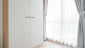 Ein Zimmer mit großem Fenster, Holztür und hellem Boden.